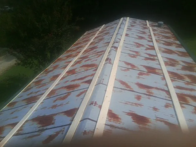 Rusted metal roof panels with new wood purlins before replacement — Storm Damage Roof Repair in Melrose by Roofing Brothers